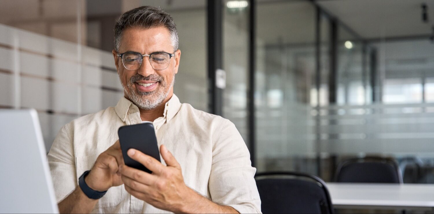 Smiling man using phone